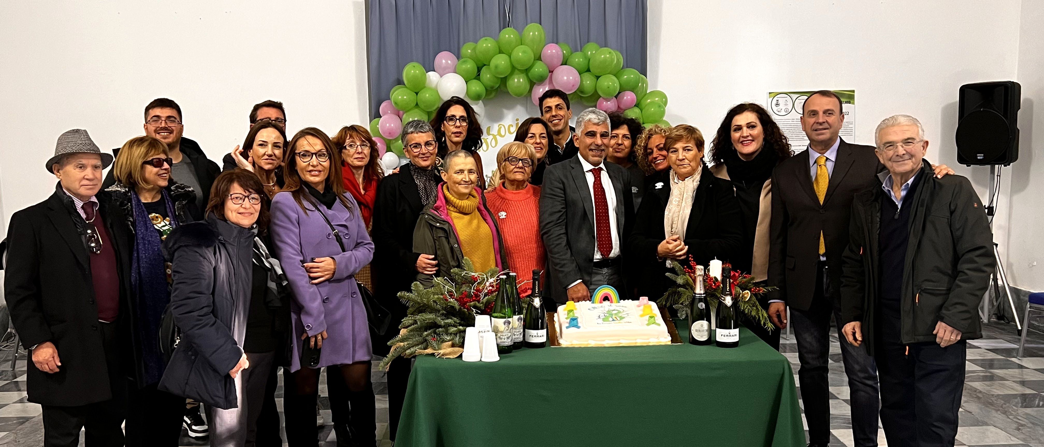 Foto degli iscritti e volontari dell'associazione Oltre il rosa la Forza della Vita in posa davanti ad una torta